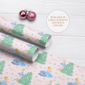 Personalised Ballerina Princess Wrapping Paper, two rolls and one sheet on a white wood background with two pink christmas baubles. Christmas wrapping paper features a ballerina princess in a blue dress decorating a large christmas tree with baubles.