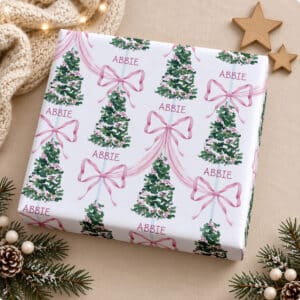 Personalised Christmas wrapping paper with pink bows, decorated trees and repeated name