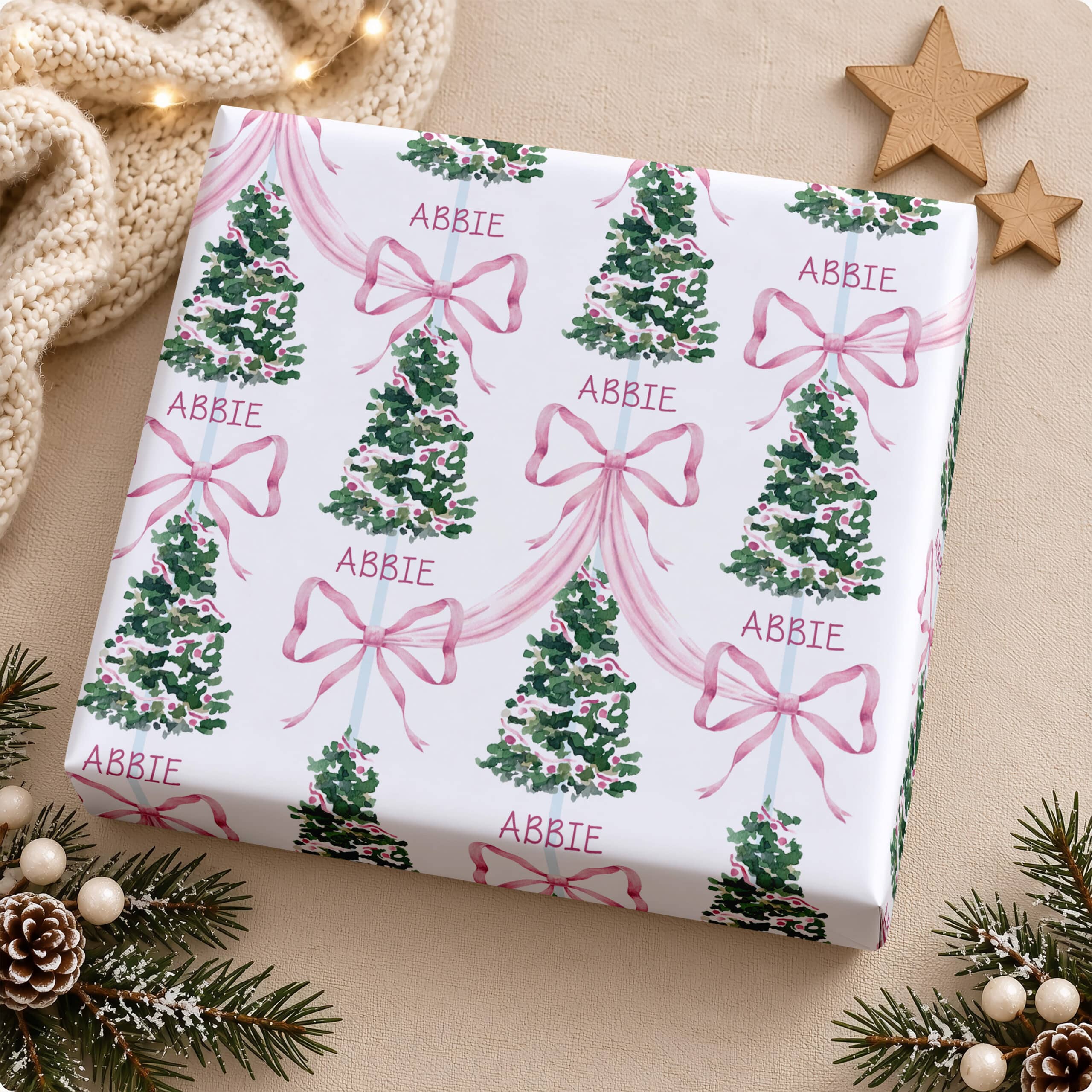 Personalised Christmas wrapping paper with pink bows, decorated trees and repeated name