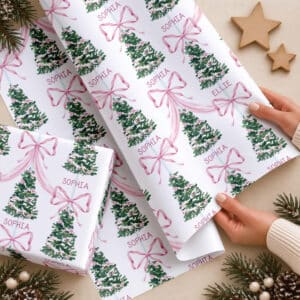 Personalised name Christmas gift wrap featuring pink ribbon bows and green Christmas trees