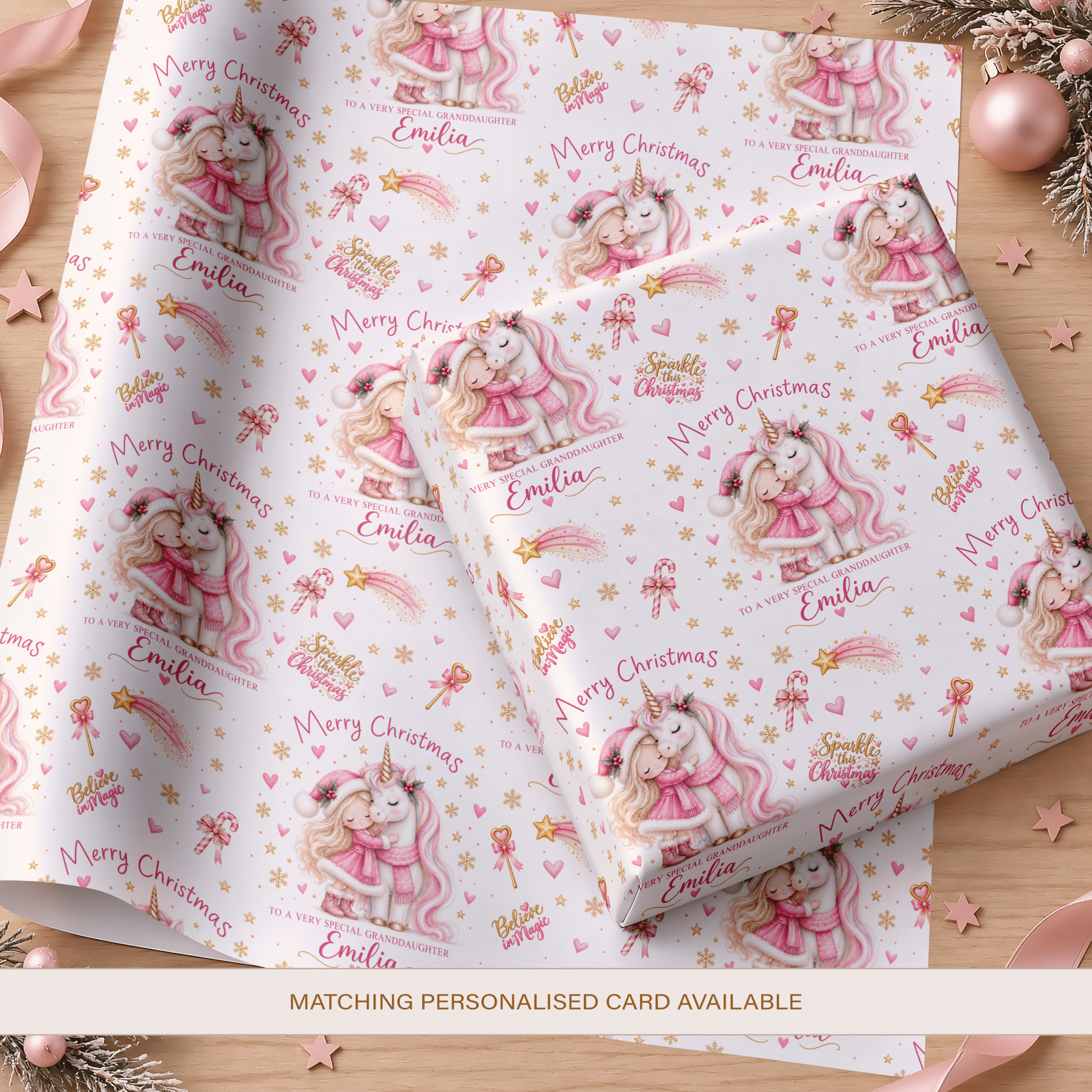 Personalised Christmas wrapping paper featuring a little girl hugging a white unicorn, with pink hearts, gold stars and festive illustrations.