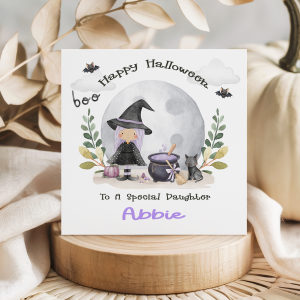 Personalised Halloween Witch Themed Card, with a witch with purple hair with a cauldron and black cat, set again a full moon with bats flying in the sky.