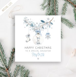 Girls personalised bunny rabbit christmas card. Featuring a blue floral wreath with christmas baubles hanging from it, a star, a christmas stocking and a bauble with a cute bunny rabbit. The card is personalised at the bottom with a name in blue ornate christmassy font.