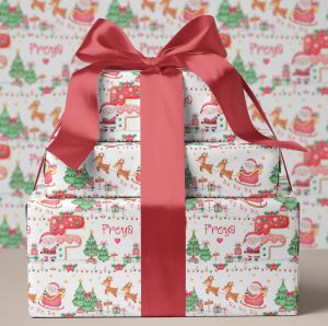 Personalised Christmas Cookie Initial Gift Wrapping Paper. The design shows the name initial in a brightly coloured cookie letter. Surrounded by santa claus in his sleigh with reindeers.