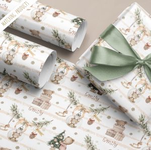 Personalised Baby's 1st Christmas Gift Wrapping Paper Featuring a cute brown teddy bear inside a bauble hanging from a pine branch, with a beige background stipe with a teddy bear standing by a christmas tree wearing stripe Pyjamas. Baby's Names in added to the gift wrapping paper in an ornate chrismassy font.
