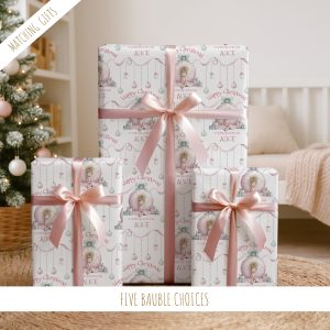 This delightful Personalised Pink Christmas Gift Wrapping Paper adds a festive and unique touch to your holiday gift-giving, featuring a little girl sitting infront of a giant pink bauble with a pile of presents, making your gifts even more special and memorable for friends and family, ensuring your presents stand out with a whimsical and festive touch. Customizable with a name, it adds a personal touch that makes gift-giving extra special and ensures your presents stand out under the tree.