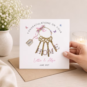Personalised new house card with decorative keys, pink ribbon, floral details and the recipients' names.