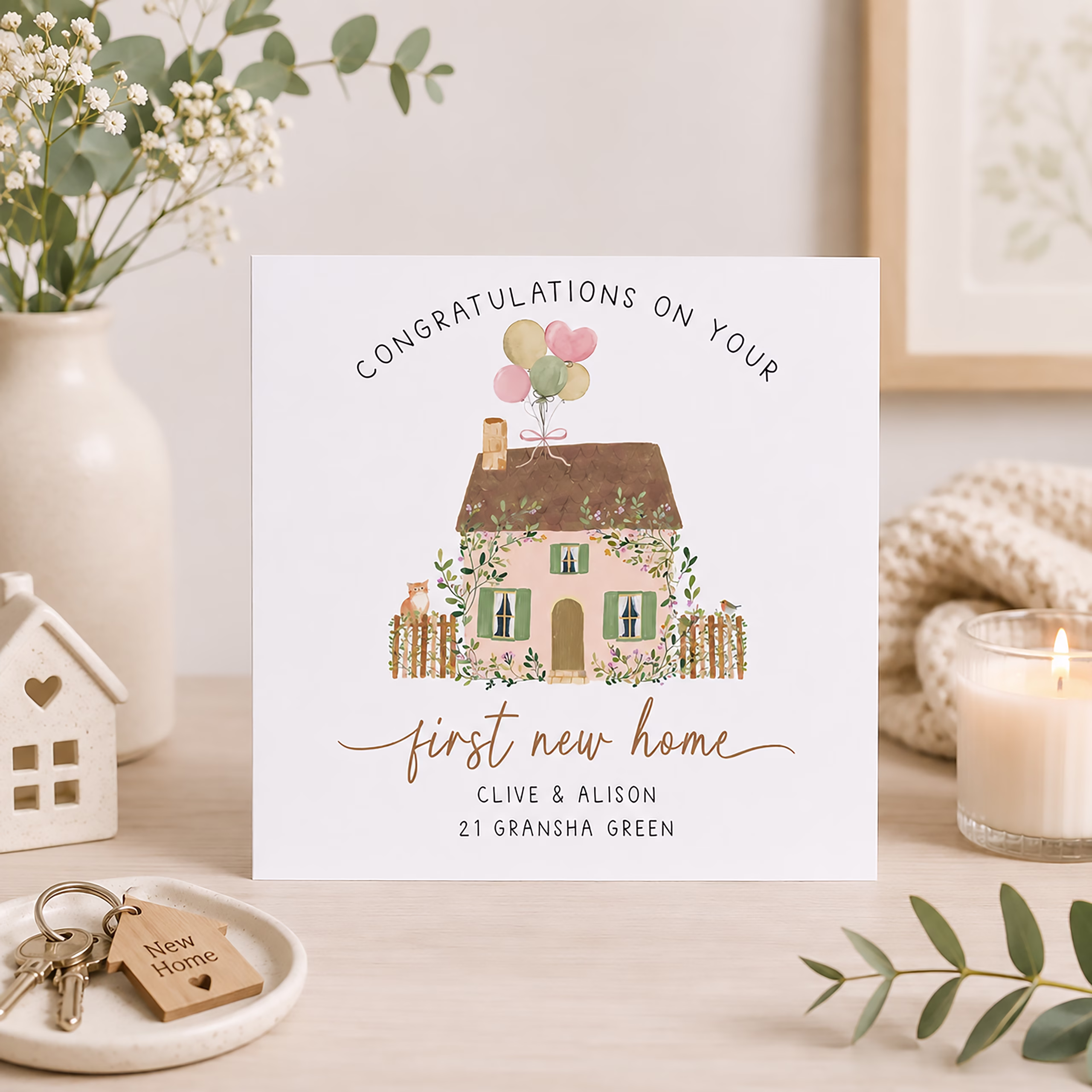 First new home congratulations card with a pretty cottage illustration, flowers, balloons and personalised address.
