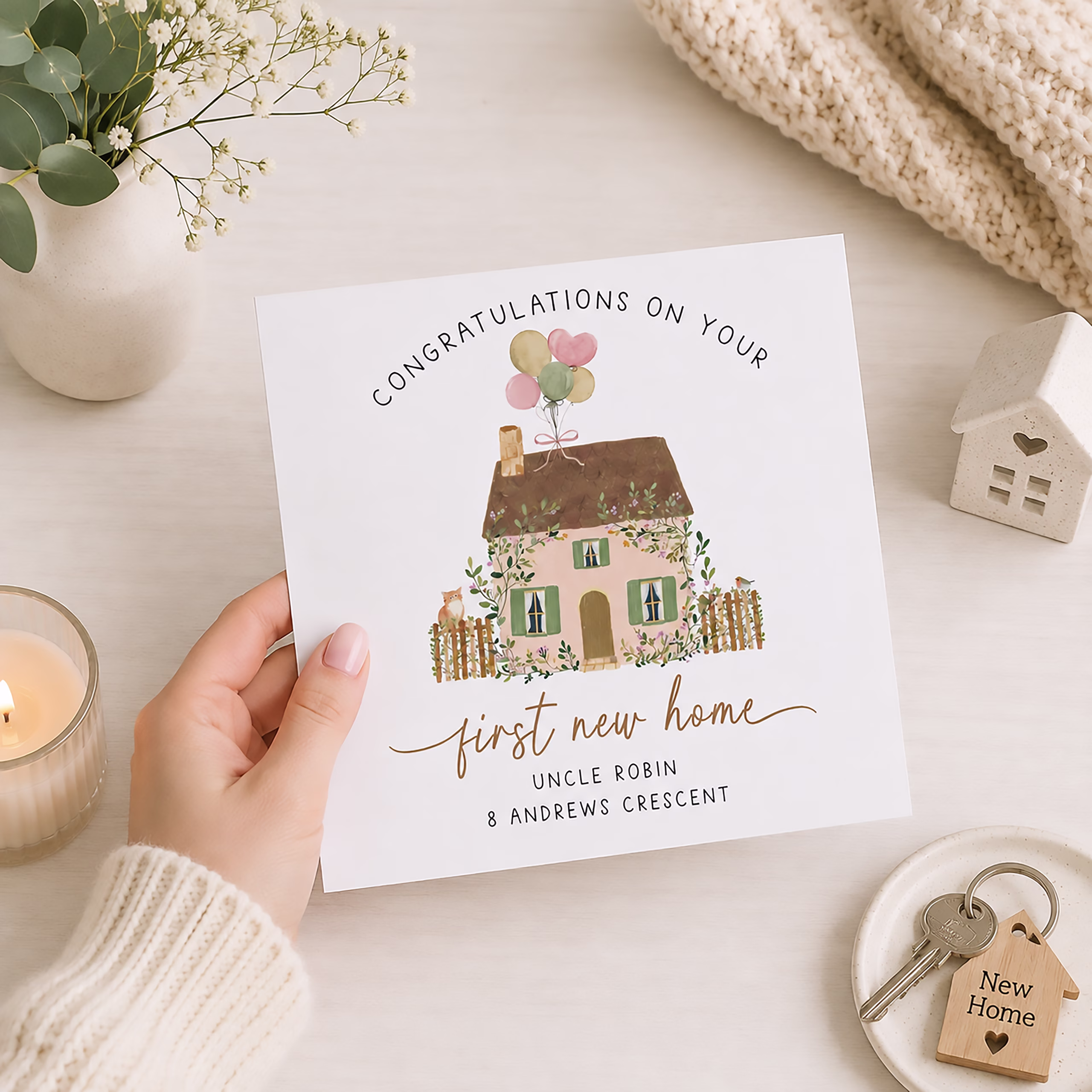 Square personalised new home card featuring a country cottage with balloons, garden flowers and Samuel and Evie's new address.