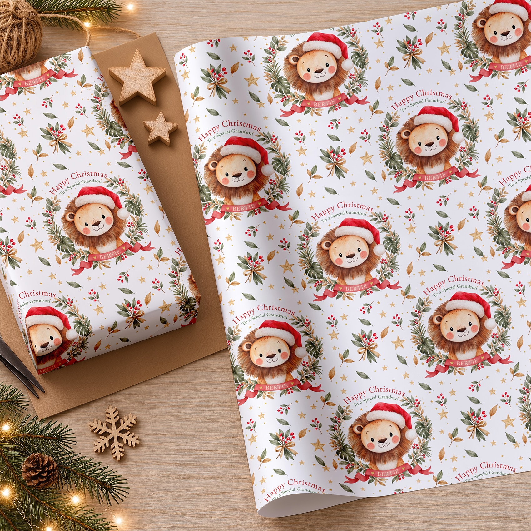 Personalised Christmas gift wrapping paper with a repeating watercolour lion design, festive foliage, red ribbons and gold stars.